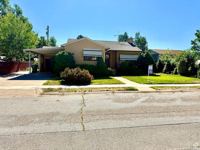 5166 S 2150 W, Roy, UT 84067 - view of front of house with driveway, an attached carport, brick siding, and a chimney