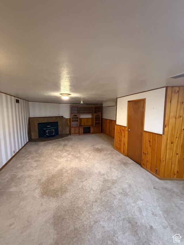 5166 S 2150 W, Roy, UT 84067 - unfurnished living room with wood walls, a fireplace, carpet, and a wainscoted wall