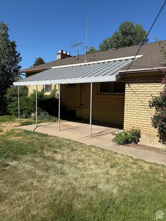 5166 S 2150 W, Roy, UT 84067 - rear view of property featuring brick siding, a yard, a chimney, roof with shingles, and a patio area