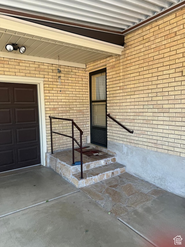 5166 S 2150 W, Roy, UT 84067 - doorway to property featuring a garage, brick siding, and a porch