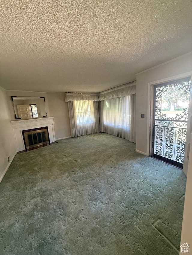 5166 S 2150 W, Roy, UT 84067 - unfurnished living room featuring a textured ceiling, healthy amount of natural light, carpet, and a glass covered fireplace