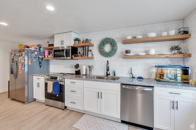 7194 N Clear Meadow Way, Eagle Mountain, UT 84005 - kitchen with open shelves, appliances with stainless steel finishes, tasteful backsplash, light wood-style floors, and white cabinetry