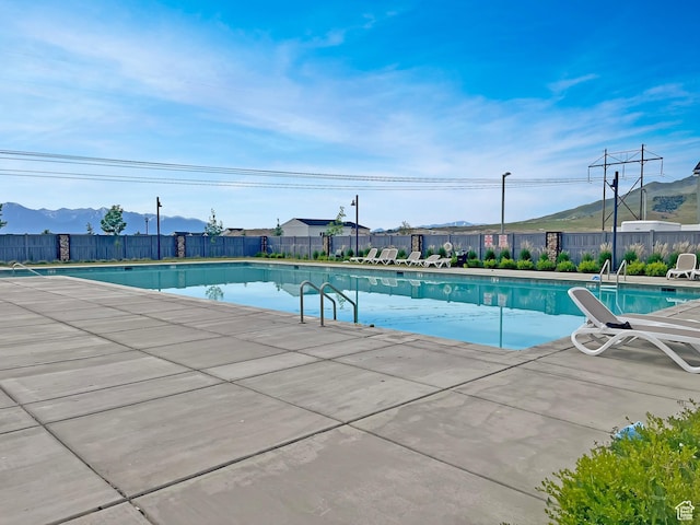7194 N Clear Meadow Way, Eagle Mountain, UT 84005 - community pool featuring a fenced backyard, a mountain view, and a patio area