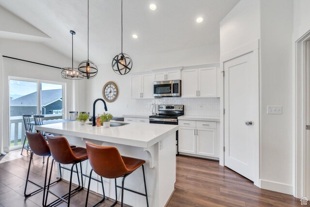 7194 N Clear Meadow Way, Eagle Mountain, UT 84005 - kitchen with appliances with stainless steel finishes, a center island with sink, tasteful backsplash, light countertops, and a breakfast bar area