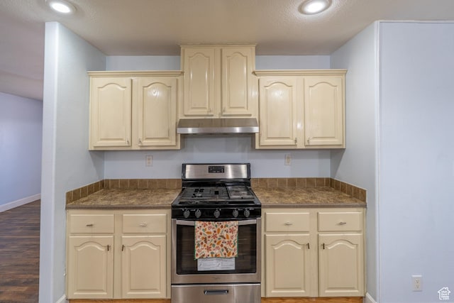 975 S 400 E, Moab, UT 84532 - kitchen with stainless steel gas range oven, under cabinet range hood, cream cabinets, dark countertops, and recessed lighting