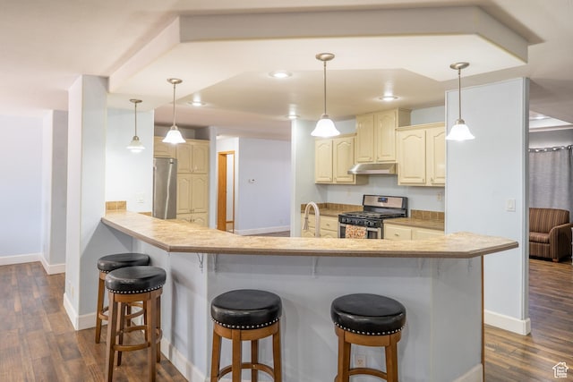 975 S 400 E, Moab, UT 84532 - kitchen featuring stainless steel appliances, under cabinet range hood, a breakfast bar area, dark wood-style floors, and recessed lighting