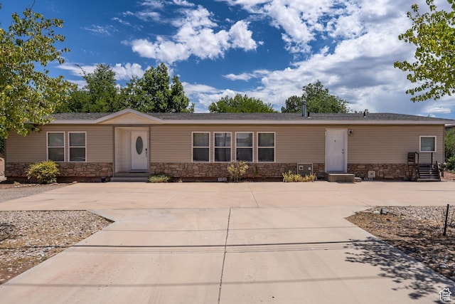 975 S 400 E, Moab, UT 84532 - manufactured / mobile home with stone siding, driveway, and entry steps