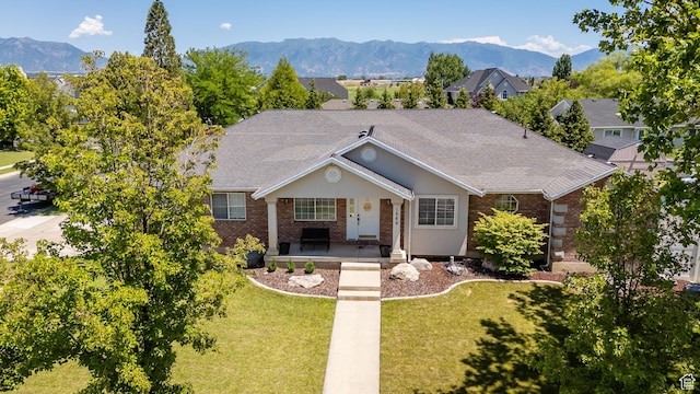 1569 Troon Cir, Syracuse, UT 84075 - ranch-style home with a porch, brick siding, a front yard, and a mountain view