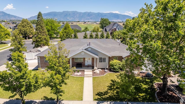 1569 Troon Cir, Syracuse, UT 84075 - view of front of property with covered porch, brick siding, a front lawn, and a mountain view
