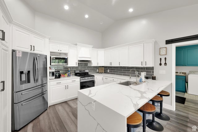 1569 Troon Cir, Syracuse, UT 84075 - kitchen with appliances with stainless steel finishes, a breakfast bar area, white cabinets, custom exhaust hood, and high vaulted ceiling