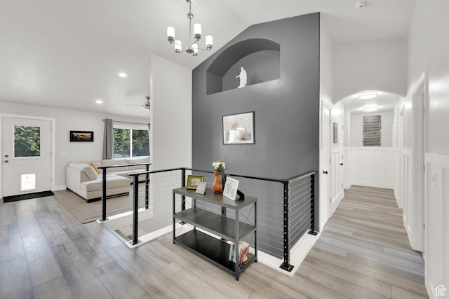 1569 Troon Cir, Syracuse, UT 84075 - hallway with an upstairs landing, light wood-style flooring, high vaulted ceiling, a chandelier, and recessed lighting