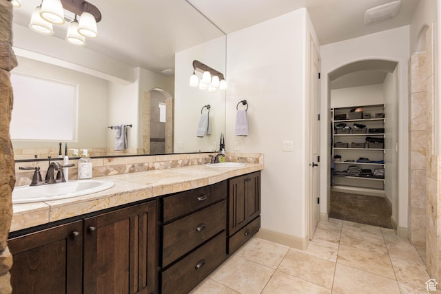4352 W 2440 S, Hurricane, UT 84737 - bathroom featuring double vanity, a walk in closet, tile patterned floors, and backsplash