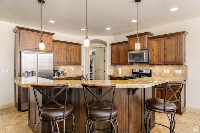 4352 W 2440 S, Hurricane, UT 84737 - kitchen with appliances with stainless steel finishes, recessed lighting, tasteful backsplash, arched walkways, and hanging light fixtures