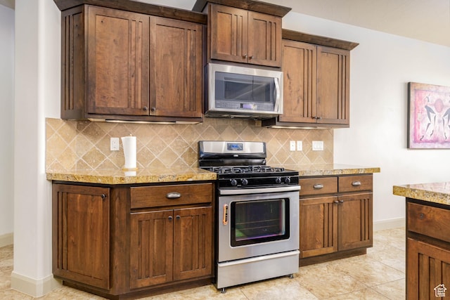4352 W 2440 S, Hurricane, UT 84737 - kitchen featuring stainless steel appliances, tasteful backsplash, light stone counters, and light tile patterned floors