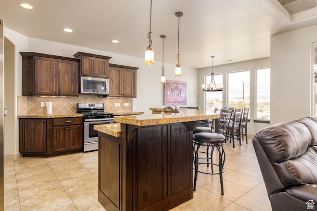 4352 W 2440 S, Hurricane, UT 84737 - kitchen featuring stainless steel appliances, open floor plan, a breakfast bar, tasteful backsplash, and a chandelier