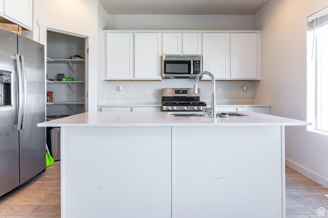 538 S Musk Ave W, Grantsville, UT 84029 - kitchen featuring appliances with stainless steel finishes, light wood-style floors, light countertops, and white cabinetry
