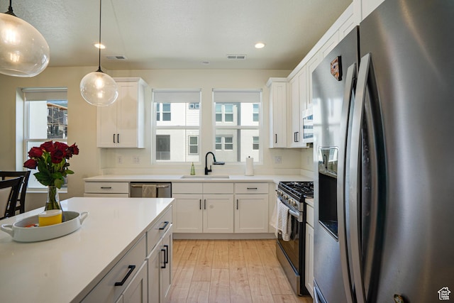 604 N Sego Way Unit 207, Farmington, UT 84025 - kitchen with appliances with stainless steel finishes, light wood-type flooring, white cabinets, healthy amount of natural light, and recessed lighting
