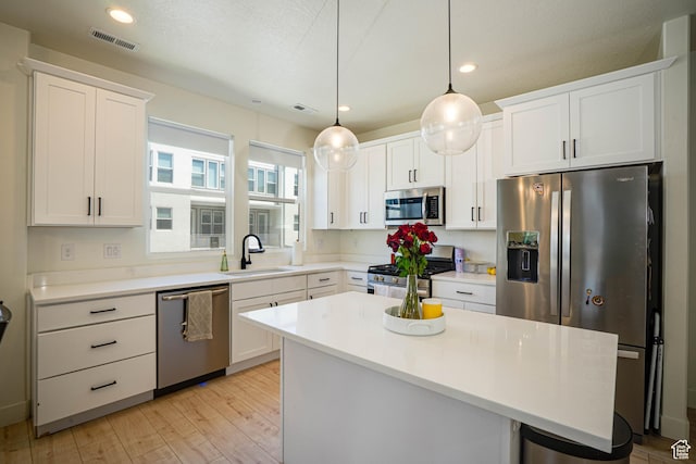 604 N Sego Way Unit 207, Farmington, UT 84025 - kitchen with appliances with stainless steel finishes, light wood-type flooring, white cabinets, recessed lighting, and light countertops