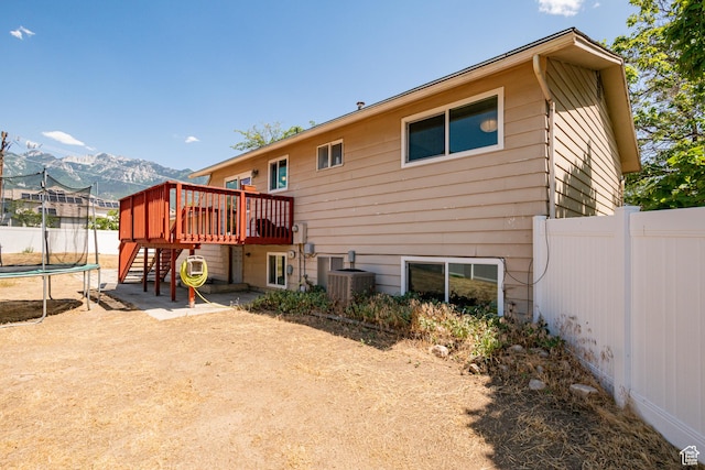 991 E Sunburn Ln, Sandy, UT 84094 - back of house featuring a trampoline, a deck with mountain view, and stairs