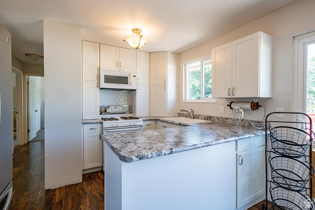 991 E Sunburn Ln, Sandy, UT 84094 - kitchen with white appliances, dark wood finished floors, healthy amount of natural light, and a peninsula