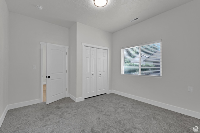 2136 Union Ave, Ogden, UT 84401 - unfurnished bedroom featuring carpet flooring, a textured ceiling, and a closet