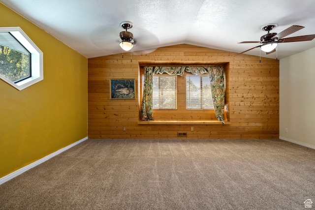 610 S Maple Dr, Woodland Hills, UT 84653 - carpeted spare room featuring wooden walls, lofted ceiling, plenty of natural light, a ceiling fan, and a textured ceiling