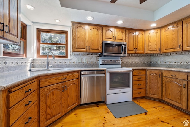 610 S Maple Dr, Woodland Hills, UT 84653 - kitchen with stainless steel appliances, brown cabinets, light wood-style flooring, decorative backsplash, and recessed lighting
