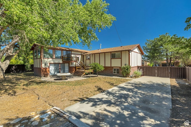 6292 S Mount Vista Dr, Taylorsville, UT 84129 - view of front facade with concrete driveway, a sunroom, stairs, a gate, and a deck