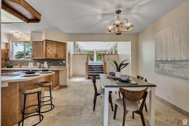6292 S Mount Vista Dr, Taylorsville, UT 84129 - dining area featuring stairway, a chandelier, and light stone finish flooring