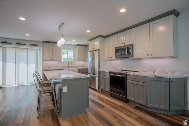 5183 W Cadenza Dr, West Jordan, UT 84081 - kitchen featuring stainless steel appliances, gray cabinets, dark wood-type flooring, recessed lighting, and light stone counters