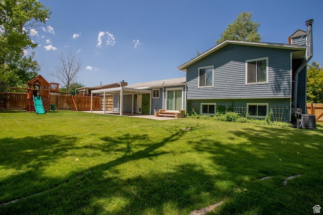 5183 W Cadenza Dr, West Jordan, UT 84081 - back of property with a fenced backyard, a patio area, a playground, and a chimney