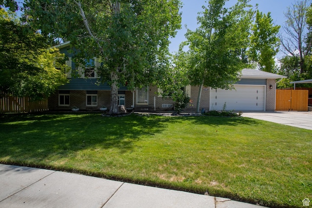 5183 W Cadenza Dr, West Jordan, UT 84081 - view of property hidden behind natural elements with brick siding, concrete driveway, and an attached garage
