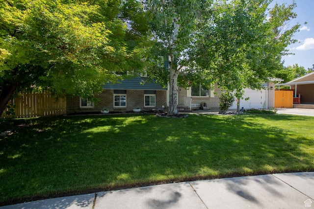 5183 W Cadenza Dr, West Jordan, UT 84081 - view of property hidden behind natural elements featuring brick siding, an attached garage, and concrete driveway