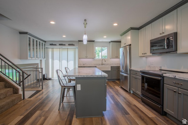 5183 W Cadenza Dr, West Jordan, UT 84081 - kitchen with electric stove, gray cabinetry, stainless steel fridge, light stone countertops, and a center island