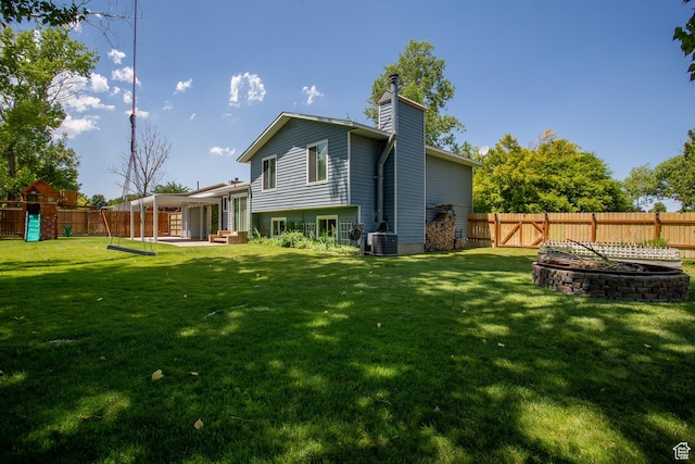 5183 W Cadenza Dr, West Jordan, UT 84081 - back of property featuring a fenced backyard, a chimney, a patio, and a playground