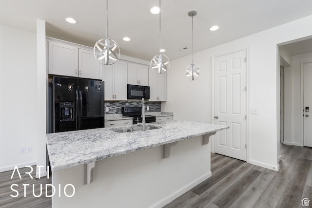 5241 S 1250 W, Riverdale, UT 84405 - kitchen with black appliances, a kitchen breakfast bar, backsplash, wood finished floors, and white cabinets