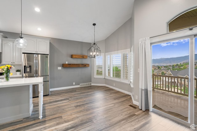 311 E Edgemont Dr S, North Salt Lake, UT 84054 - kitchen featuring stainless steel fridge with ice dispenser, wood finished floors, light countertops, a chandelier, and decorative light fixtures