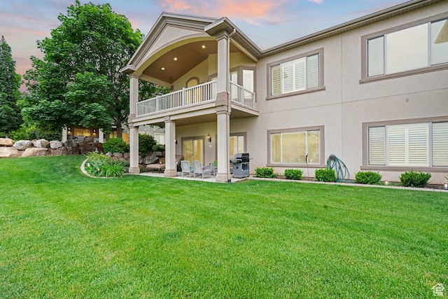 311 E Edgemont Dr S, North Salt Lake, UT 84054 - back of property featuring a balcony, a patio, stucco siding, and a lawn