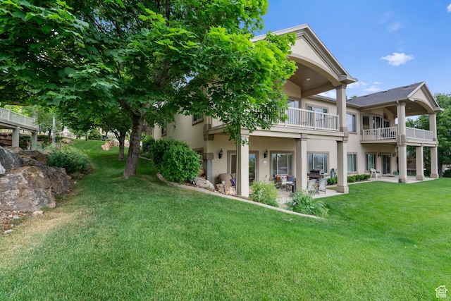 311 E Edgemont Dr S, North Salt Lake, UT 84054 - back of house with a balcony, a lawn, a patio, and stucco siding