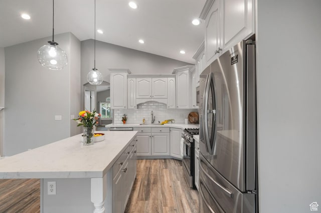 311 E Edgemont Dr S, North Salt Lake, UT 84054 - kitchen featuring appliances with stainless steel finishes, wood finished floors, white cabinets, decorative backsplash, and recessed lighting