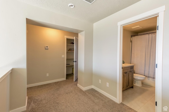 69 W 2200 S, Kaysville, UT 84037 - unfurnished bedroom featuring light colored carpet, ensuite bath, a textured ceiling, and a spacious closet