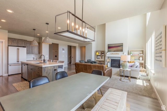 69 W 2200 S, Kaysville, UT 84037 - dining room featuring dark wood-type flooring, recessed lighting, a glass covered fireplace, and a towering ceiling