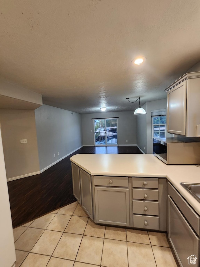 1132 W 1390 S, Orem, UT 84058 - kitchen featuring a peninsula, stainless steel microwave, gray cabinetry, a textured ceiling, and healthy amount of natural light