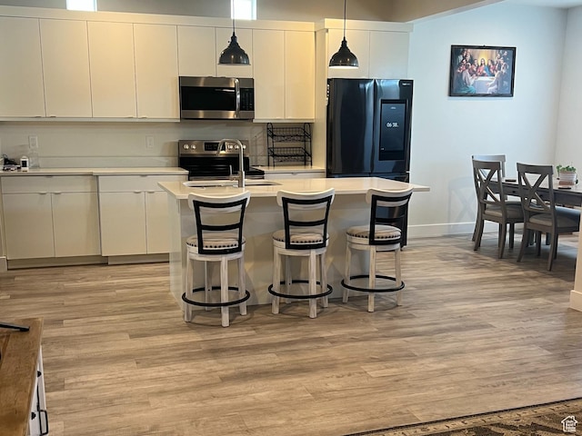 3589 S Xenon Dr W, West Valley City, UT 84119 - kitchen with stainless steel appliances, light wood-type flooring, light countertops, and hanging light fixtures