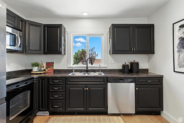 291 S 700 E, Spanish Fork, UT 84660 - kitchen with stainless steel appliances, light wood-type flooring, dark countertops, and dark cabinetry