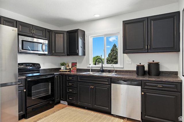 291 S 700 E, Spanish Fork, UT 84660 - kitchen with stainless steel appliances, dark countertops, light wood-type flooring, dark cabinets, and recessed lighting