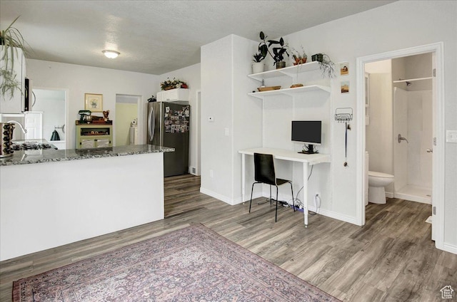 3241 Grant Ave, Ogden, UT 84401 - kitchen with freestanding refrigerator, wood finished floors, stone counters, open shelves, and a desk
