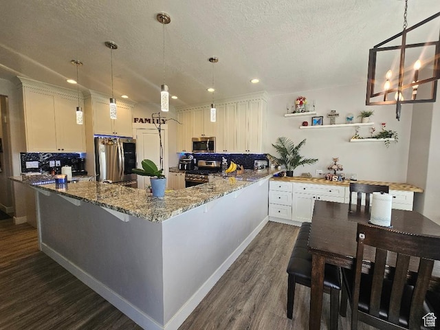 826 S 300 W, Vernal, UT 84078 - kitchen with appliances with stainless steel finishes, dark wood-style floors, a textured ceiling, stone countertops, and pendant lighting