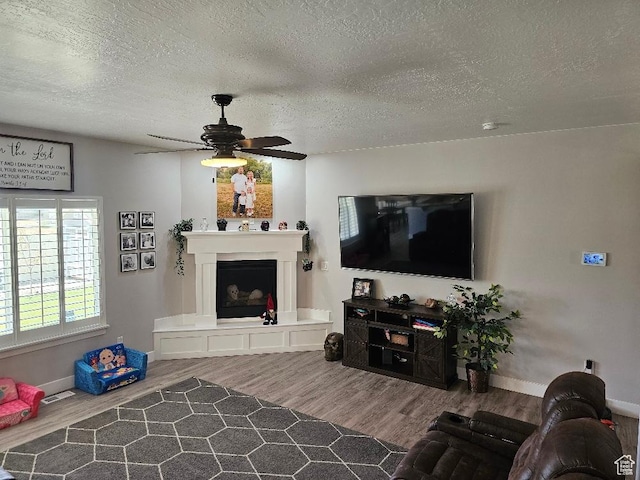 826 S 300 W, Vernal, UT 84078 - living room with wood finished floors, a fireplace with raised hearth, ceiling fan, and a textured ceiling