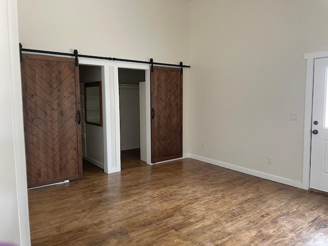 1375 N State St, Sigurd, UT 84657 - unfurnished bedroom featuring wood finished floors, a barn door, and a walk in closet
